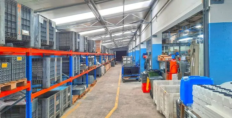 Armazém industrial com estantes de paletes e corredor de circulação marcado