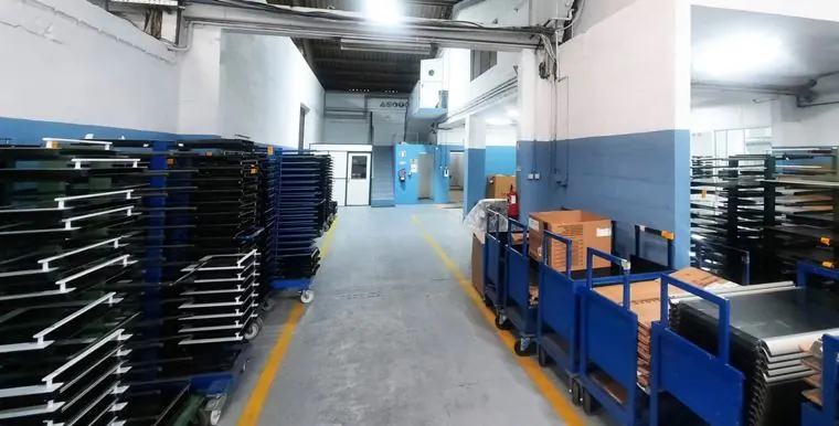 Área de produção industrial com carros de transporte e paredes pintadas