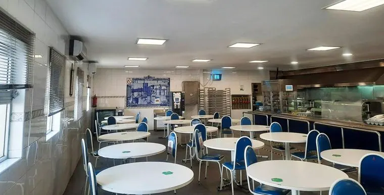 Refeitório de unidade industrial remodelado, com mesas redondas