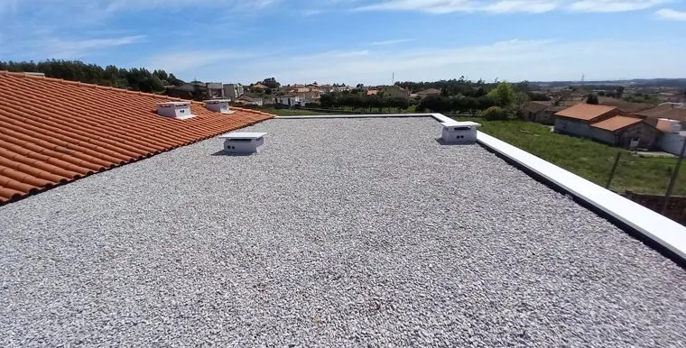 Cobertura plana em godo de um edifício, com vista para a cidade