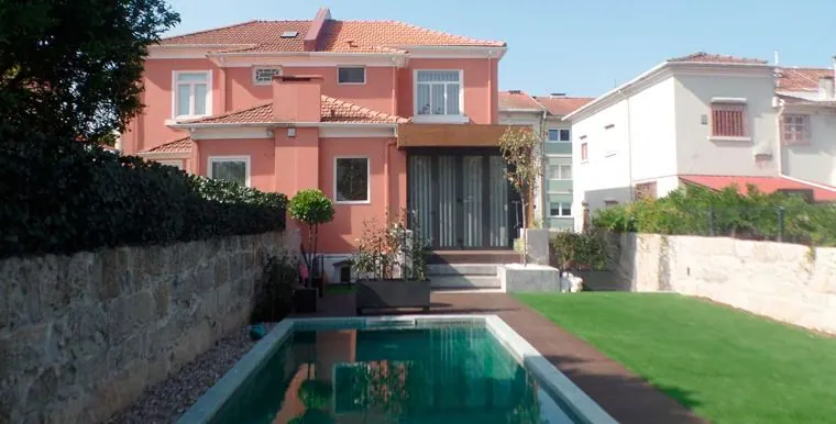Moradia antiga reabilitada, pintada de coral, com piscina e jardim nas traseiras