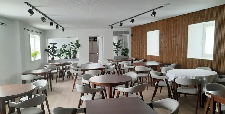 Sala de refeições com teto de calhas de iluminação e madeira